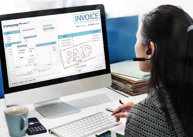 Finance staff reviewing a paid invoice on screen, showing the invoice verification and payment stage of the procure-to-pay process.