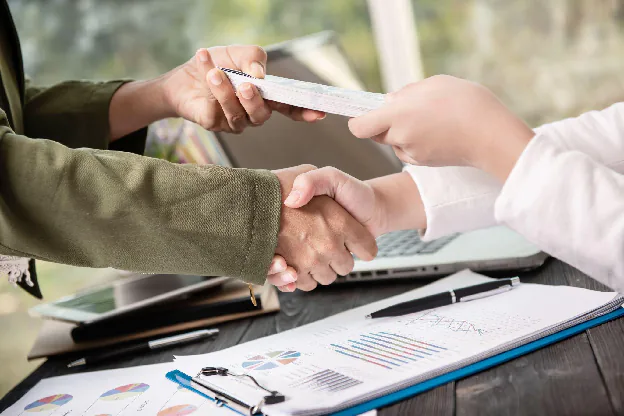 Supplier agreement meeting with signed documents and a handshake, showing the approval and contract stage that supports the procure-to-pay process